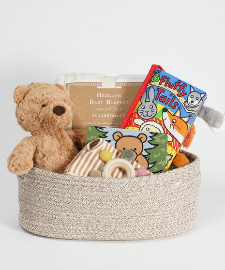 new baby gift basket featuring teddy bear, blanket, and baby books.