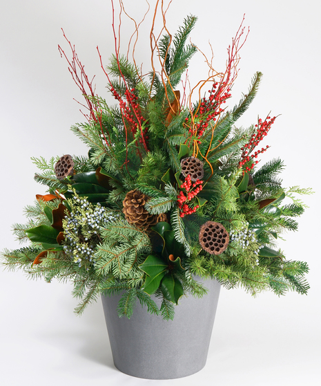 christmas planter with winter greens, berries, and pinecones in a large ceramic container