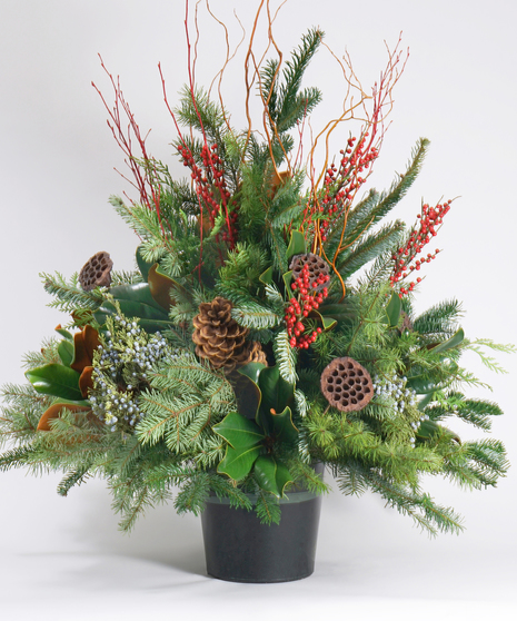 christmas planter with winter greens, berries, and pinecones in a large ceramic container