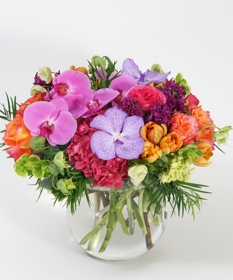 luxury floral design of pink hydrangea, orange tulips, vanda orchids and seasonal greens.