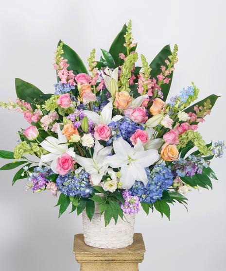 funeral basket arrangement of pastel toned blooms