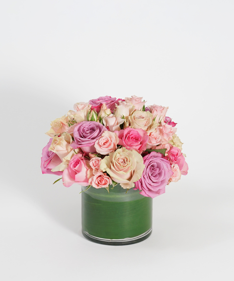 low and lush floral arrangement of cream, peach and pink roses