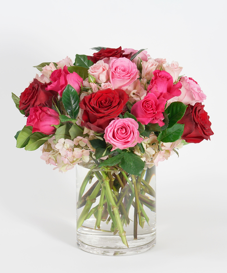 lush arrangement of red and pink roses accented with pink hydrangea