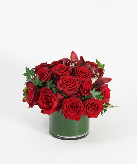 red roses accented with burgundy orchid