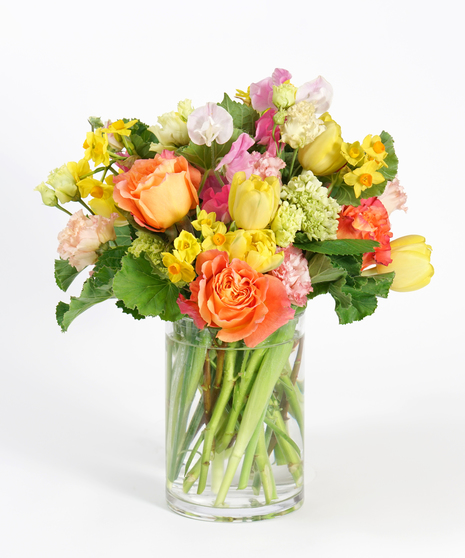 gardeny floral design featuring yellow tulips and orange accented with sweet pea and gloriosa lilies